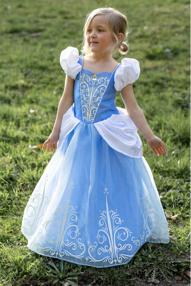 Young girl wearing light blue Cinderella princess dress with white puff sleeves and silver embroidery outdoors