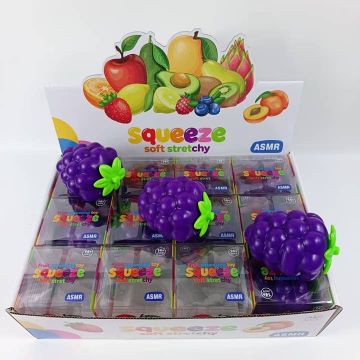 Purple grape-shaped squishy squeeze toys displayed in retail box packaging with fruit graphics