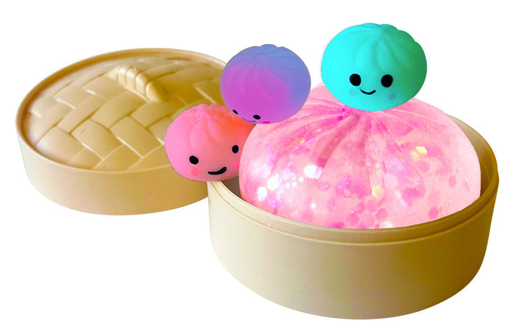 Pink glittery squishy dumpling toy with three cute cartoon baby dumplings in a bamboo steamer basket