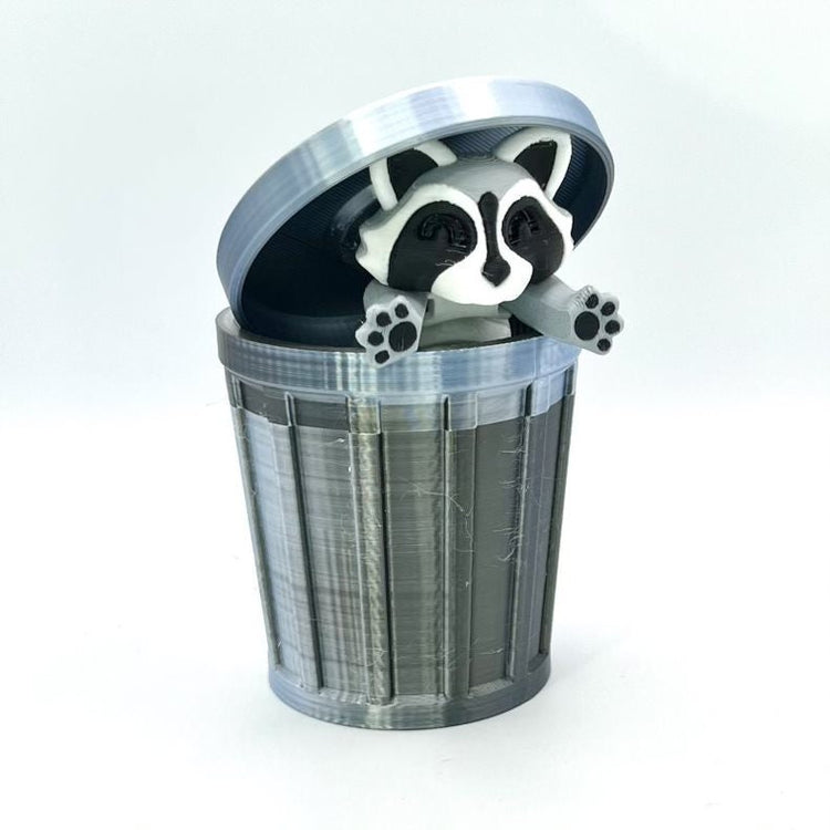 3D printed raccoon figure popping out of a gray miniature trash can with lid