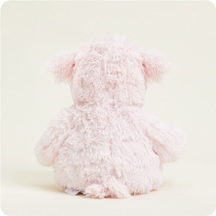 Rear view of pink fluffy Warmies pig stuffed animal with shaggy texture and floppy ears