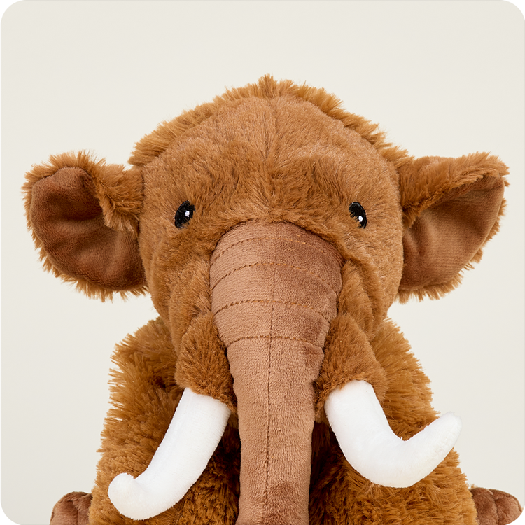 Warmies Wooly Mammoth stuffed animal with brown fur, trunk, and white tusks
