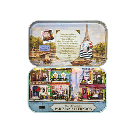 Open tin box displaying DIY Parisian Afternoon miniature scene with tiny Eiffel Tower and cafes