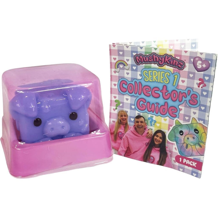 MushyKinz Series 1 purple pig squishy toy in pink box with collector's guide booklet