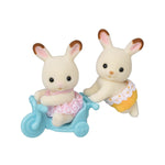 Two Calico Critters Chocolate Rabbit Twin figures, one in pink on blue tricycle, one in yellow outfit