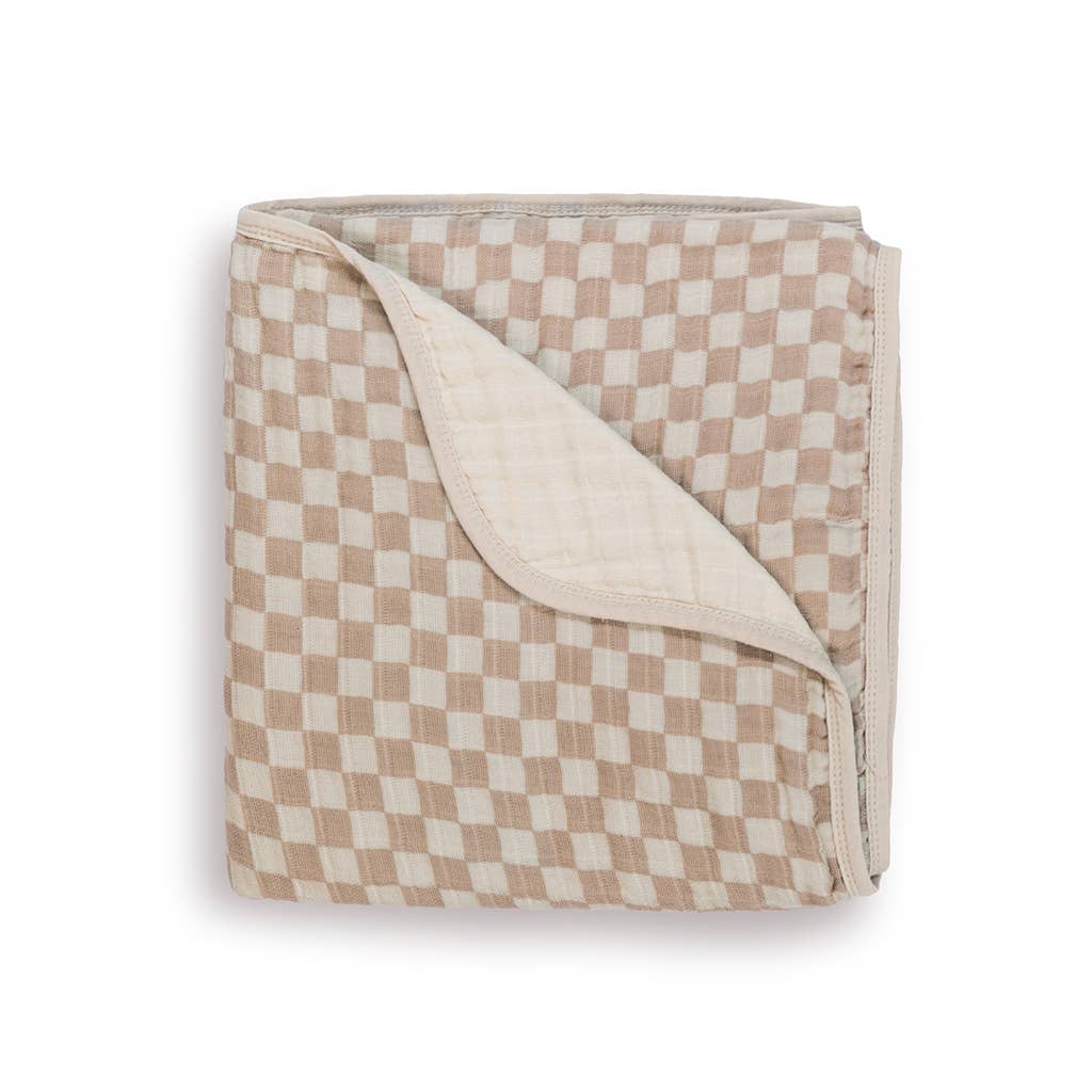 Folded muslin baby blanket with taupe and cream checkerboard pattern, showing cream reverse side