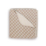 Folded muslin baby blanket with taupe and cream checkerboard pattern, showing cream reverse side