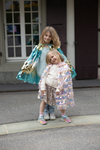 Two girls wearing sequin capes, smaller child in gold light pink pailette cape outdoors