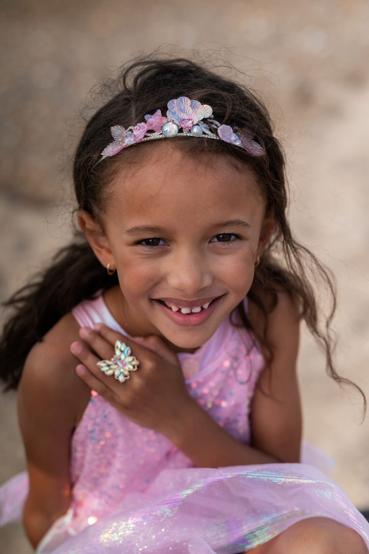 Young girl wearing iridescent pink tiara with seashells and butterfly ring jewelry set