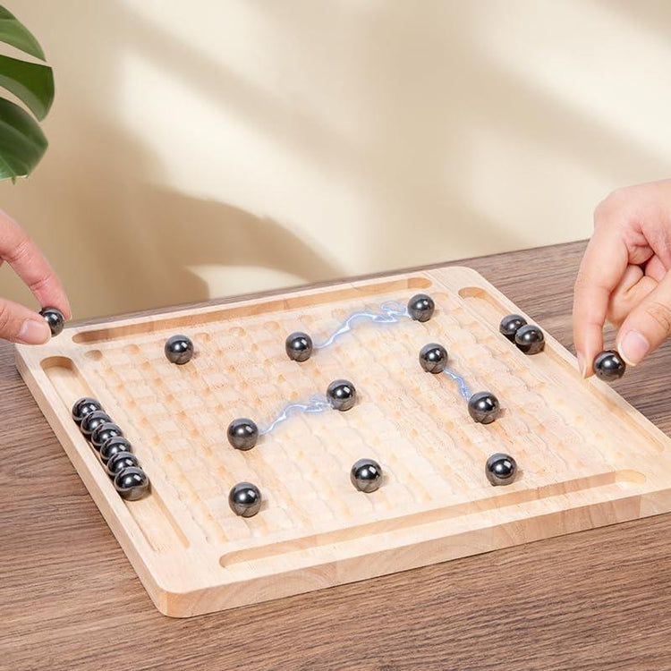 Two players using magnetic steel balls on a wooden grid board game set