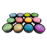 Twelve glittery glow-in-the-dark squishy dumpling toys in colorful holographic assortment in black baskets