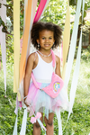 Young girl wearing mint pink tutu skirt with white top, fairy wings, and wand outdoors
