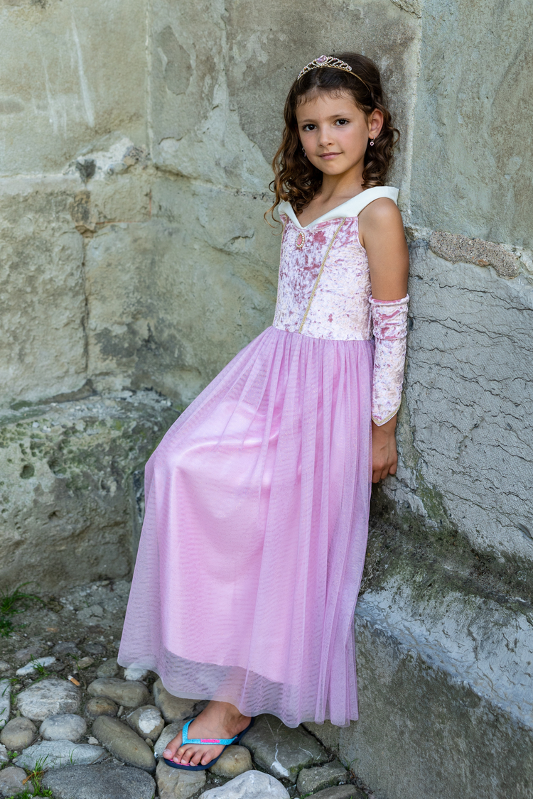 Child wearing pink velvety Sleeping Beauty princess gown with matching arm warmers and tiara