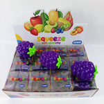 Purple grape-shaped squishy squeeze toys displayed in retail box packaging with fruit graphics
