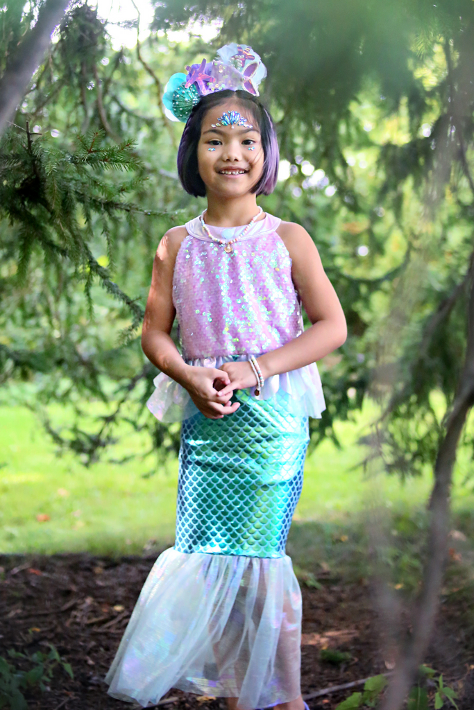 Young girl wearing lilac sequin mermaid dress with teal scale skirt and decorative crown headpiece