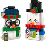 Two LEGO snowman ornaments with top hats, scarves, carrot noses, and holiday accessories on white background.