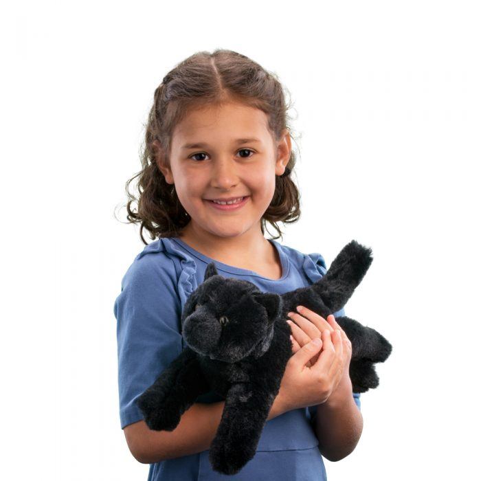 Young girl smiling and holding a soft black cat stuffed animal plush toy