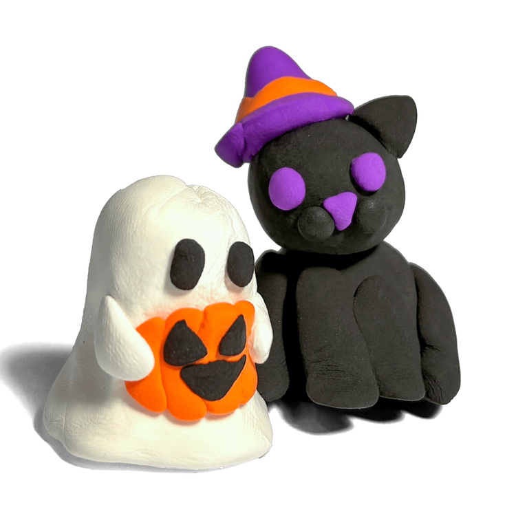Handmade clay ghost holding jack-o-lantern beside black cat wearing purple witch hat