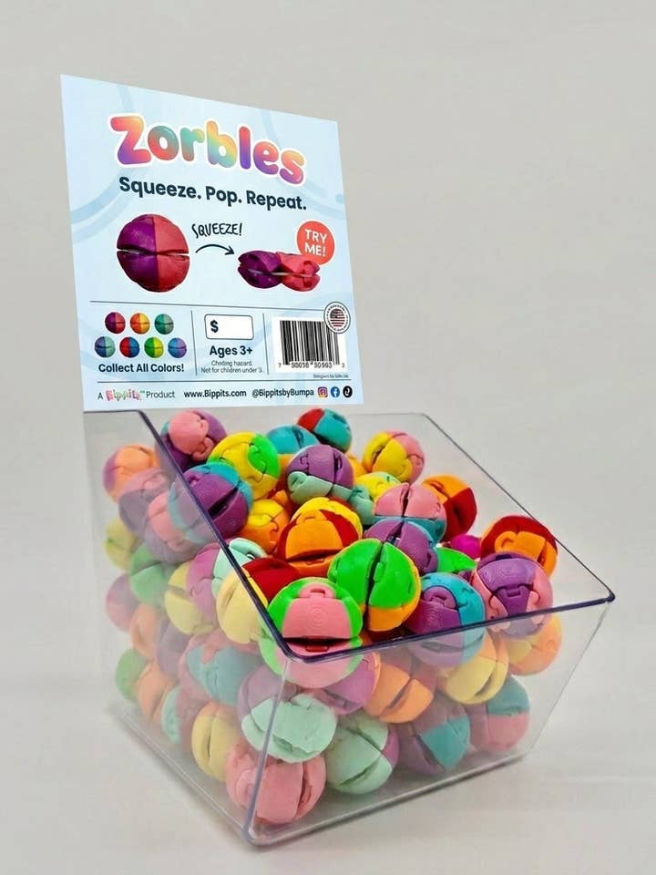 Zorbles multicolor fidget toys displayed in a clear acrylic bin with branded signage