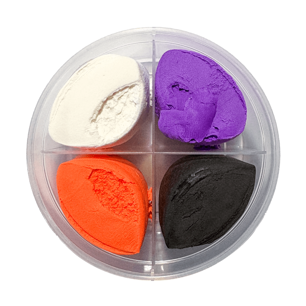 Round clear container with four sections of Halloween-themed air-dry clay in white, purple, orange, and black