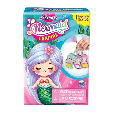 Three iridescent mermaid keychain charms in teal, purple, and green held in a hand