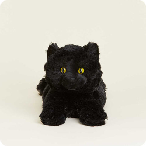 Black plush stuffed cat toy with yellow eyes lying down on white background