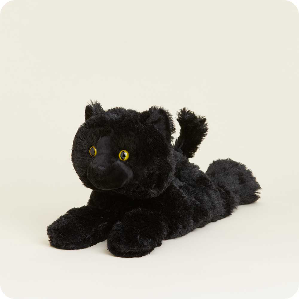 Black plush stuffed cat toy with yellow eyes lying down on white background