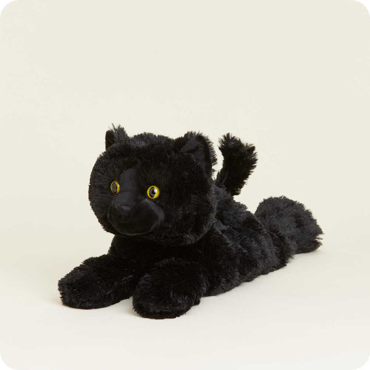 Black plush stuffed cat toy with yellow eyes lying down on white background