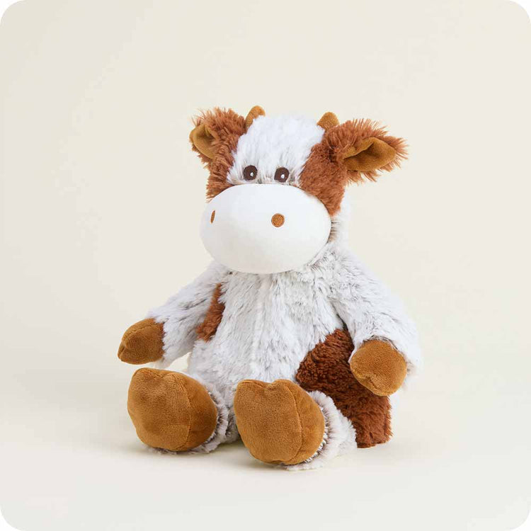 Warmies Cinnamon Latte Cow plush stuffed animal with brown and white fur sitting upright