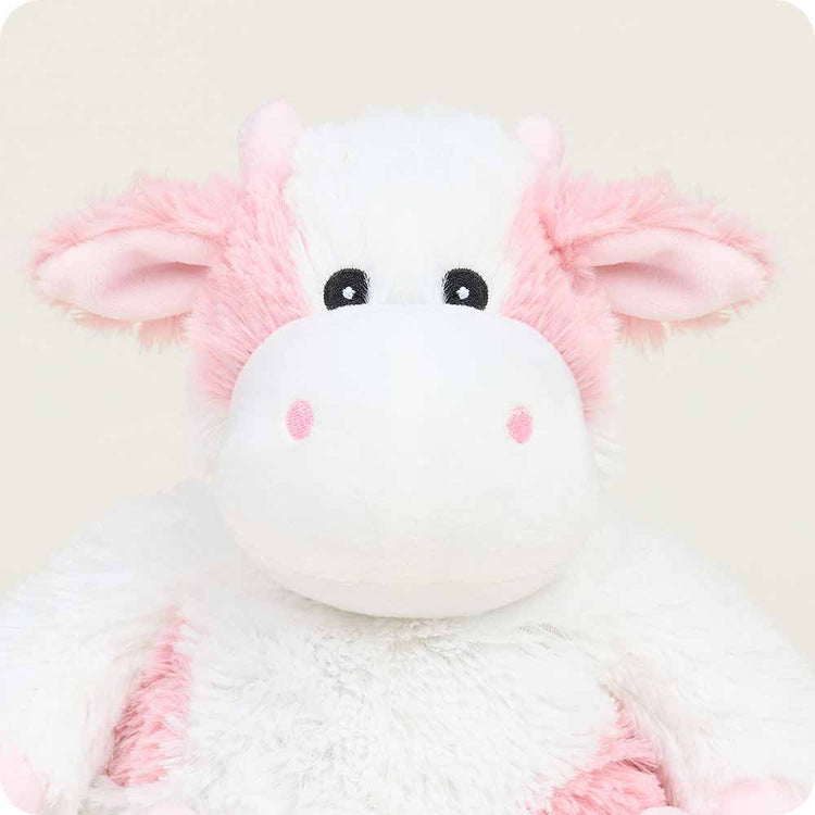 Warmies Strawberry Cow stuffed animal with white plush body and pink accents