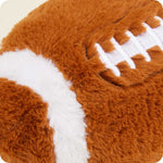 Close-up of plush brown football stuffed animal with white laces and stripe details