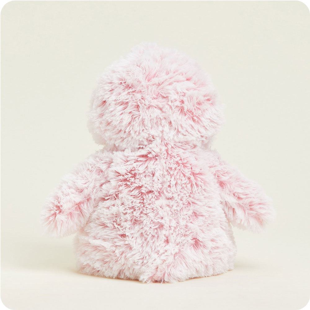 Pink fluffy Warmies penguin stuffed animal shown from the back on neutral background