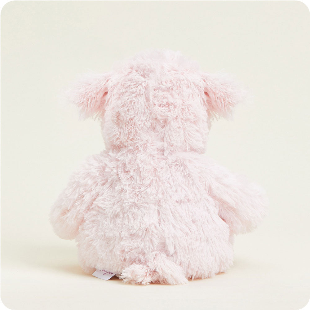 Rear view of pink fluffy Warmies pig stuffed animal with shaggy texture and floppy ears