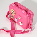 Hot pink silicone crossbody bag with cute food charm decorations including cookie, strawberry, and avocado