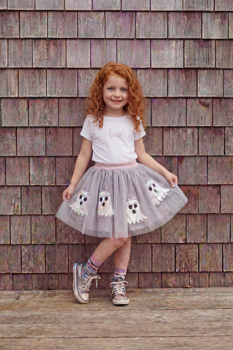 Young girl wearing grey tulle ghost appliqué skirt with white boo t-shirt and silver sneakers