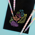 Tutti Fruitti scented multicolor gel pens with striped barrels beside colorful fruit artwork on black paper