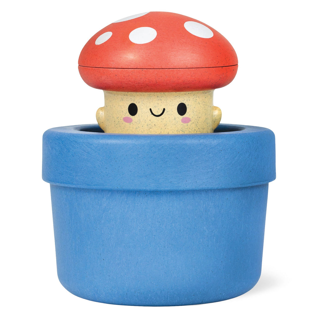 Wooden bath toy mushroom character with red spotted cap sitting in blue pot