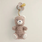 Bitzy Pal plush bear toy attached to a natural rubber pacifier on neutral background