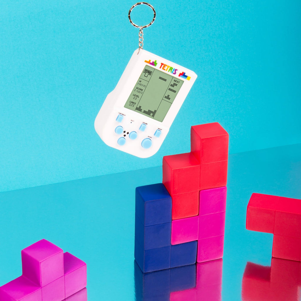 Tetris keyring mini arcade game in white with colorful Tetris block props on blue background