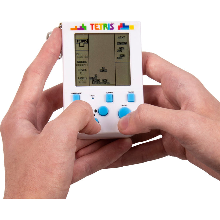 Two hands holding a miniature white Tetris keyring arcade handheld game with blue buttons