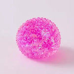 Pink translucent spiky squishy orb ball toy with textured crystal-like surface on white background