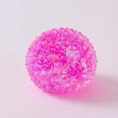Pink translucent spiky squishy orb ball toy with textured crystal-like surface on white background