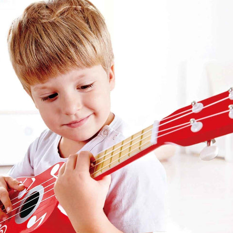 Hape red wooden toy ukulele with white musical notes and four strings for children