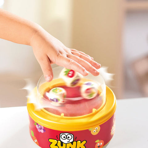 Zunk pattern matching game with dome dice shaker, fruit-themed cards, and colorful fruity characters