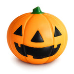 Orange jack-o-lantern squishy toy with black carved face and green stem