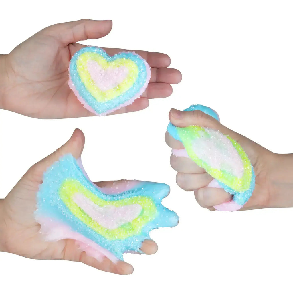 Hands holding and squishing a heart-shaped pastel multicolor textured slime toy