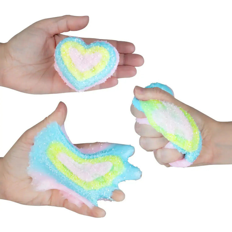 Hands holding and squishing a heart-shaped pastel multicolor textured slime toy