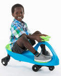 Smiling child riding an aqua blue and lime green Plasma Car ride-on toy on white background