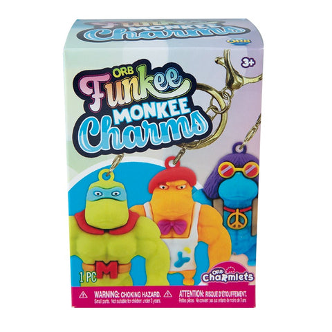 Hand holding three colorful Funkee Monkee Charmlets keychain figures on gold rings