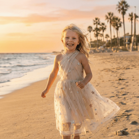 Children's gold tulle dress with multicolor sequin embellishments displayed on mannequin